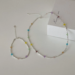 Colorful crystal beaded silver necklace and bracelet set on a clean white background