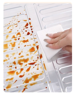 Close-up of aluminum splash guard being cleaned with a wipe showing easy stain removal