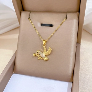Detail showing a luxurious gold-plated swallow pendant necklace with micro-pave diamonds