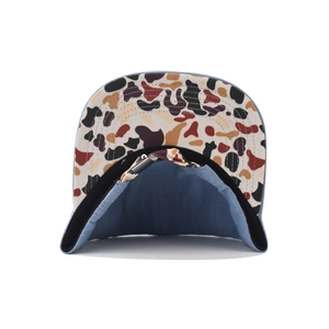 Detail of denim baseball cap showing camo print brim and adjustable metal buckle