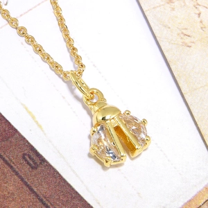 Detailed close-up of a golden beetle pendant set with sparkling white cubic zirconia stones