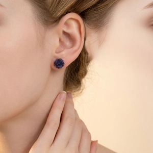 Élégantes boucles d'oreilles roses en résine violet foncé sculptées en 3D sur un mannequin