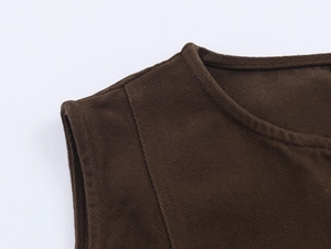 Dettaglio della cucitura della spalla e trama a coste su questo top in denim marrone