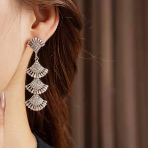Detail of silver layered fan-shaped tassel earrings with sparkling rhinestones on model