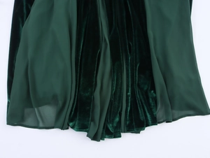 Detail of dark green velvet hemline with sheer mesh patchwork and soft drape texture