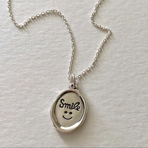 Minimalist 925 sterling silver necklace featuring an irregular oval smile seal pendant