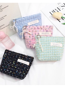Detail of tweed zipper pouches with pearl charms and sequins in four elegant colors