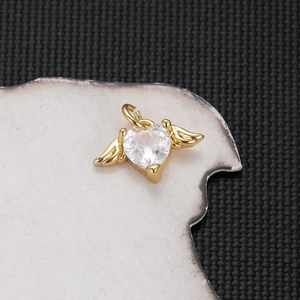 Detailed view of a gold-plated winged heart pendant with sparkling clear zircon stone