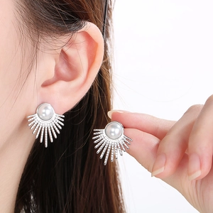 Detailed view of silver sunburst stud earrings with white pearl center for women