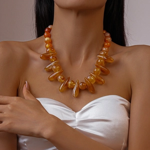 Acrylic amber-colored beaded necklace with teardrop pendants on female model