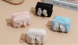 Corduroy mini coin purses in four colors with lace bows and pearl charms on beige background