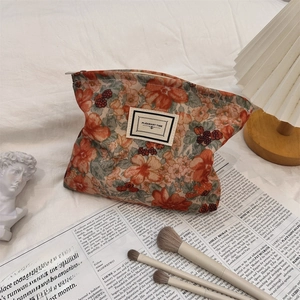 Detail of floral corduroy makeup bag with metal zipper and printed fabric label