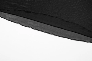Detail of elegant black lettuce hem edge on slim fit knit dress with wave texture