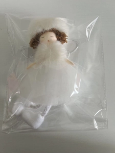 Close-up of white angel pendant with tulle dress and plush hat in clear packaging
