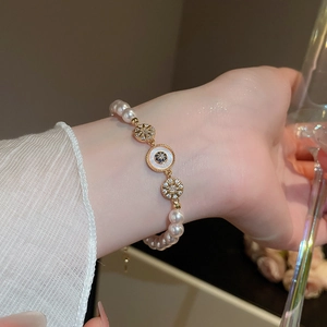 Détail du bracelet en perles plaqué or 18 carats avec pendentif œil et zircone au poignet