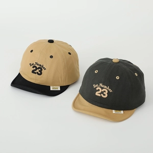Detail of color-block cotton toddler caps with Est. Number 23 embroidery and woven labels
