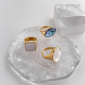 Exaggerated geometric gold rings featuring natural mother of pearl and abalone shell insets
