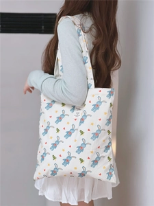 Detailed view of the cute rabbit print fabric and woven label on a white cotton tote bag