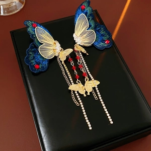 Detailaufnahme von Vintage-Zirkon-Schmetterling-Ohrringen mit Stickerei und Quasten