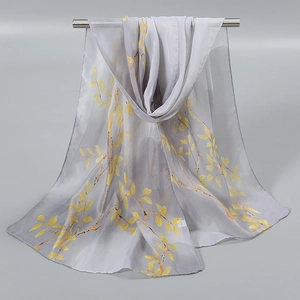 Détail d'une écharpe en mousseline gris clair avec imprimé floral sur tige métallique