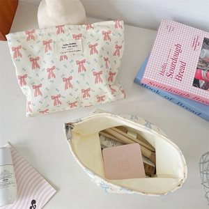 Close-up of canvas cosmetic bag showing floral bow print and internal storage space