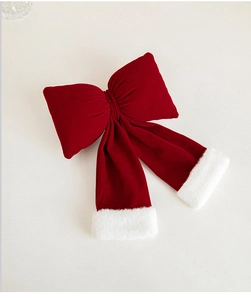 Detail of red velvet Christmas bow with soft white faux fur trim and plush texture