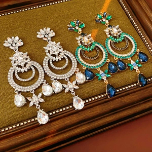 Détails de boucles d'oreilles vintage avec cristaux colorés sur un cadre vert