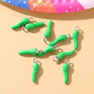 Flat lay of nine green chili pepper charms for DIY jewelry making on a beige base