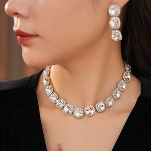 Close-up of elegant sparkling round crystal necklace and tassel earrings on female model