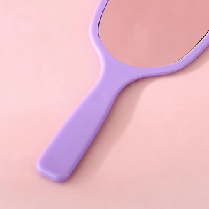 Elegant purple handheld makeup mirror with sleek plastic frame on a soft pink background