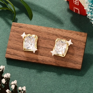 Detail of French style gold floral earrings with zircon on festive wooden block