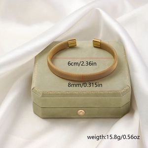Golden woven mesh titanium steel open bangle bracelet with measurements on green velvet