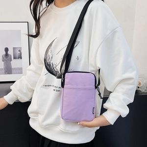 Minimalist light purple square crossbody bag with adjustable black strap worn by model