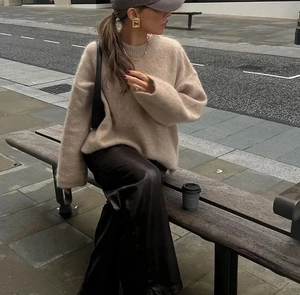 Détail d'un pull en maille beige oversize avec texture mohair douce et épaules tombantes