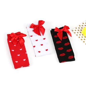 Three pairs of Valentine socks with red heart and lip patterns plus satin bows