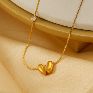 Golden puffy letter W pendant necklace with zircon on elegant satin background