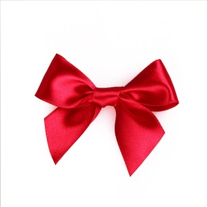 Handmade red satin ribbon bow with fishtail cut ends on white background for gift wrapping