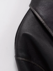Macro detail shot showing premium black PU leather texture and stitching of the jacket