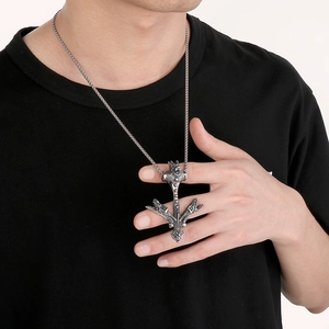 Detail of viking trident wolf pendant on silver woven chain worn by male model