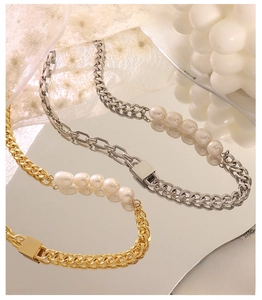 Detail of 18K gold and silver chunky chain necklaces with freshwater pearls on lace