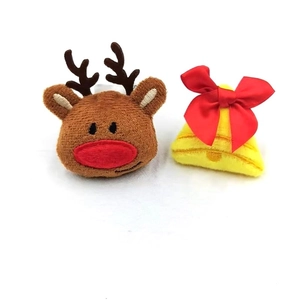 Detail view of plush Christmas reindeer brooch and yellow bell with red bow accessory