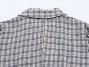 Gros plan sur la texture du tissu à carreaux gris et blanc et les coutures du col