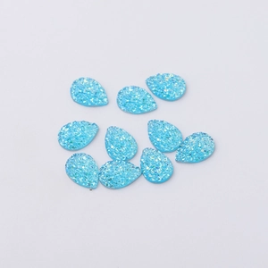 Detailed view of ten blue water drop-shaped resin charms with shimmering ice textures