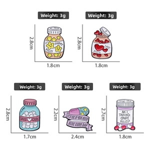 Detail view of five creative enamel pins showing weights and dimensions in centimeters