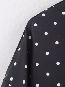 Gros plan sur le tissu noir avec motif à pois blancs et texture lisse soignée