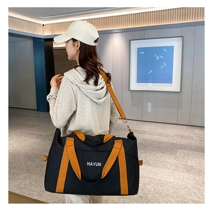 Model wearing a large multi-functional travel bag with orange details and Hayun logo