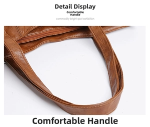 Close-up of brown faux leather tote with reinforced handles and metal zipper detail
