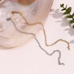 Detail of 14K gold and silver delicate chains with lobster clasp on a pearl shell background