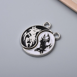 Macro shot of Yin Yang wolf charms featuring black and white enamel finish for DIY jewelry
