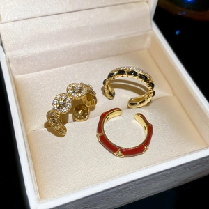 Detailed macro view of 14k gold plated rings with colorful enamel and zircon in velvet box